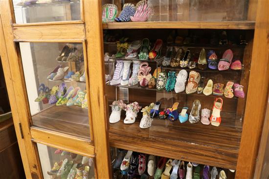 An oak cabinet containing miniature shoes